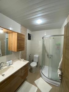 een badkamer met een glazen douche en een toilet bij Luxury apartment with sea view in Mezitli