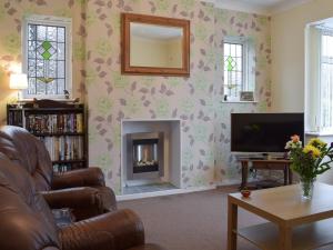 sala de estar con chimenea y TV en Robins Nest, en Samlesbury