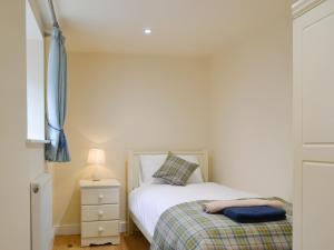 a small bedroom with a bed and a night stand at No, 1 Ash Cottage in Quatt