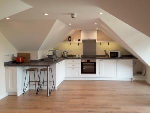 a kitchen with white cabinets and a counter in a attic at Herons Nest in Bourton on the Water