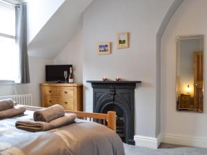 a bedroom with a fireplace with two towels on a bed at Dragonfly Cottage in Beverley