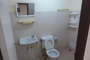 a small bathroom with a toilet and a sink at ธิติกาญจน์ อพาร์ทเม้นท์ in Ban Khlong Samrong