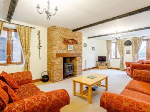 a living room with couches and a fireplace at Pantiles Barn - E3866 in Runcton Holme