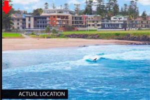 a person riding a wave on a surfboard in the ocean at Kiama beachside apartment in Kiama