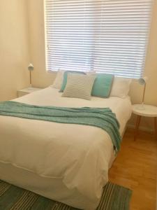 a bedroom with a large bed with pillows and a window at Kiama beachside apartment in Kiama