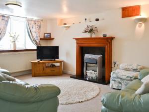 a living room with a couch and a fireplace at Deuglawdd Cottage - Hw7788 in Aberdaron