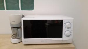 un forno a microonde bianco seduto su un bancone accanto a un mixer di Napulè a Napoli