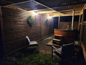 un patio con 2 sillas y una valla por la noche en Cabañas Entre copihues en Osorno