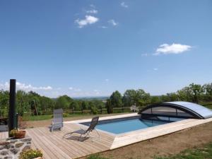 una piscina con cubierta en una terraza de madera en Gîte Carlat, 4 pièces, 6 personnes - FR-1-742-428 