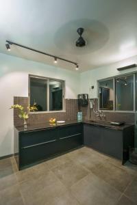 a bathroom with a sink and two mirrors at Grey Stone - Lakefront PentHouse Family Rooms in Kolhapur
