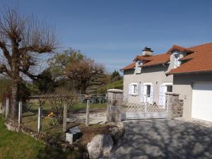 una casa blanca con una valla y un patio en Gîte Arpajon-sur-Cère, 4 pièces, 6 personnes - FR-1-742-425, en Arpajon-sur-Cère