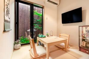 a dining room with a table and chairs and a window at 桜の宿 高田 provide two free bicycle in Kyoto