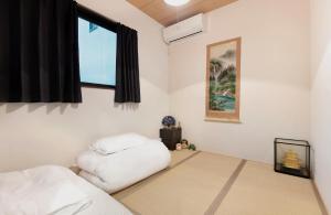 a bedroom with two beds and a window at 桜の宿 高田 provide two free bicycle in Kyoto