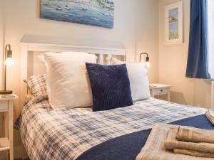 1 dormitorio con 1 cama con almohadas blancas en Garden Flat en Ryde