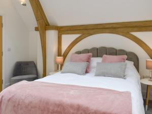 ラムズゲートにあるOld Parish Hallのベッドルーム1室(ピンクのシーツが備わる大型ベッド1台付)