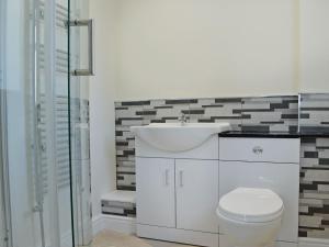 a white bathroom with a sink and a toilet at Forest Walk in Coleford
