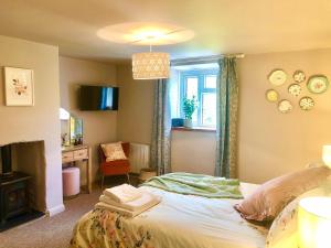 1 dormitorio con cama, escritorio y ventana en Lemon Cottage en Bickington
