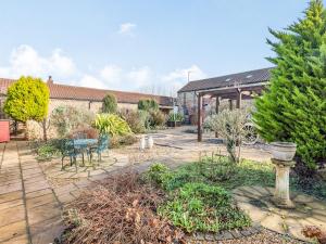 a garden with a patio with a table and chairs at The Tack Rooms - Uk37520 in Routh