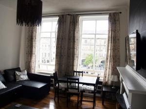 a living room with a couch and a table in front of a window at Niddry Street Apartments Edinburgh in Edinburgh