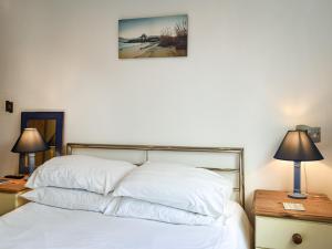 1 dormitorio con 1 cama con sábanas blancas y 2 lámparas en Pennti Treth - Uk39455, en Saint Columb Minor