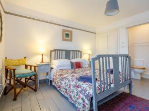 ein Schlafzimmer mit einem Bett und einem Stuhl in der Unterkunft Seafield House in Lochinver