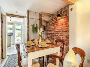 a dining room with a brick wall at Heartwarming Cottage in Wickham Market