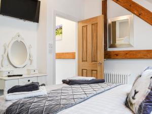 a bedroom with two beds and a mirror at Chapel Mouse Cottage in Cockermouth