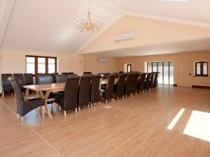 una sala de conferencias con mesa de madera y sillas en Kingfisher Barn, en Sculthorpe