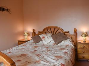 a bedroom with a bed with two night stands and two lamps at Sparrows Nest in Preston
