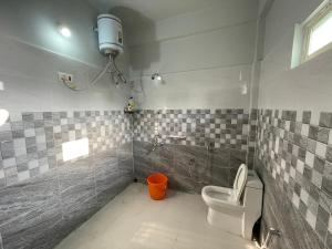 y baño con aseo y lavamanos. en Deka’s Homestay en Tezpur