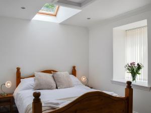 een slaapkamer met een bed met witte muren en een raam bij Kirroughtree Steading 1 - Uk5859 in Newton Stewart