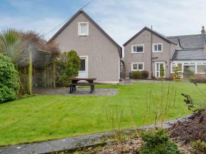 a backyard with a picnic table in front of a house at Hawthorn Cottage in Stranraer