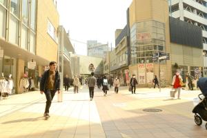 un grupo de personas caminando por una calle de la ciudad en Platon Hotel Yokkaichi, en Yokkaichi
