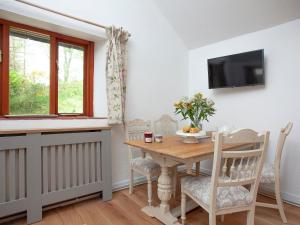 a dining room with a table and a tv at The Hayloft - Uk32686 in Sheepstor