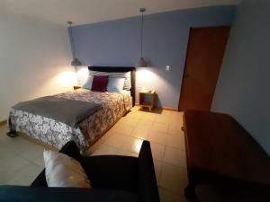 Un dormitorio con una cama y un sofá en una habitación. en Departamento Colima, en La Paz