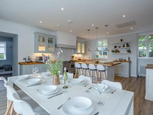 uma sala de jantar e cozinha com uma mesa branca e cadeiras em Coillemore House em Balmacara