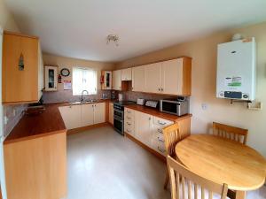 a kitchen with wooden cabinets and a wooden table at Red Lion Cottage in Chatteris