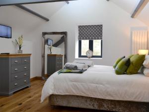een slaapkamer met een bed, een dressoir en een spiegel bij Maes Merlin in Llanddeusant