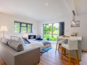 a bedroom with a bed and a table and a desk at Willow Cottage in Stonham Aspall