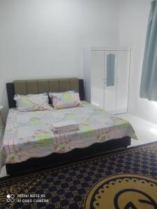 Schlafzimmer mit einem Bett und einem Spiegel in der Unterkunft Homestay Tok Kah in Kuala Terengganu