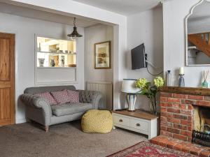 a living room with a couch and a fireplace at Willow Cottage in Stockbridge