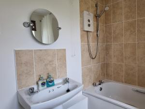 a bathroom with a sink and a tub and a mirror at Mallard Cottage - Uk33872 in Cote