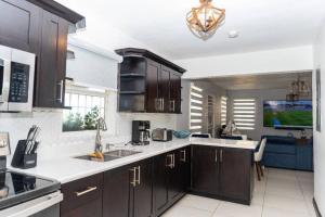 a kitchen with dark brown cabinets and a white counter top at Breathtaking Oceanfront in Portmore