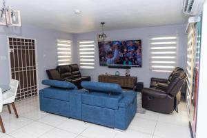 a living room with a blue couch and chairs at Breathtaking Oceanfront in Portmore