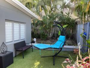 uma cadeira azul sentada na relva num quintal em Relax at Trinity Beach Getaway, Blue Lagoon, Trinity Beach em Trinity Beach