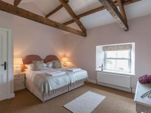 a bedroom with a bed and a window at Helwith Cottage - Ukc3455 in Marrick
