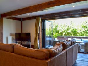 a brown leather couch in a living room with a television at Olive Lodge in Melbourne