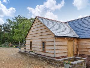 uma cabana de madeira com um telhado de gambrel em Cosy Cottage - Uk34263 em Fordingbridge