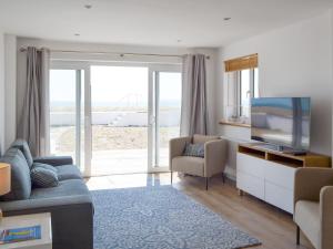 a living room with a couch and a flat screen tv at Salty Lodge in South Hayling