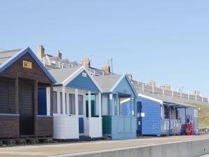 a row of colourful beach houses on a street at The Granary - E3669 in Saxtead